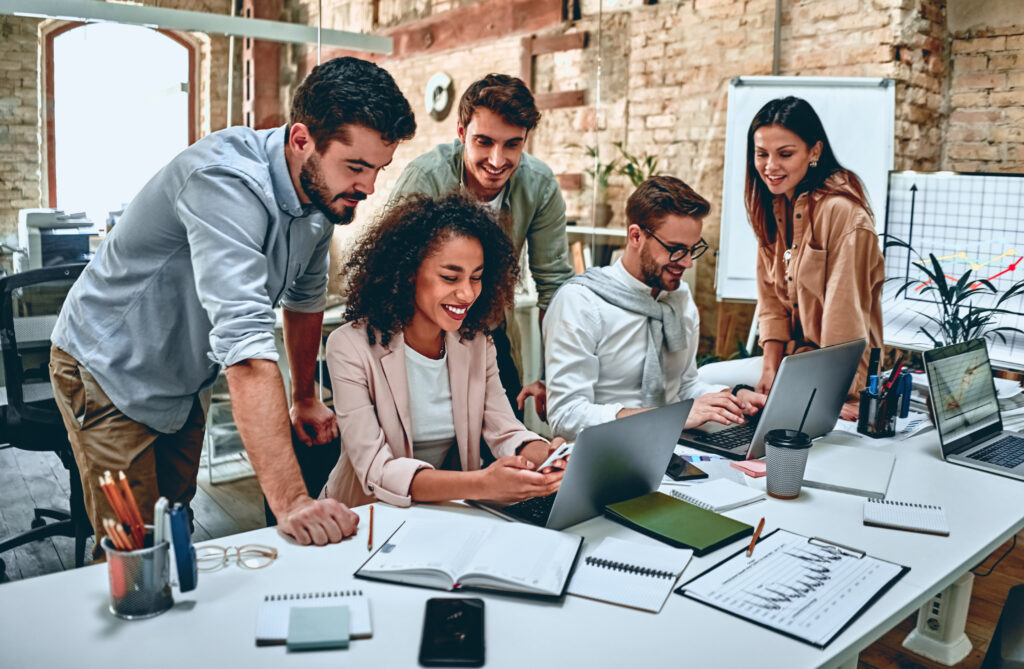 Coworkers collaborating around laptops in an office