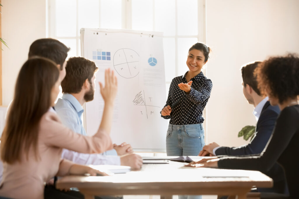 Presenter leading coworkers through a workshop at a whiteboard